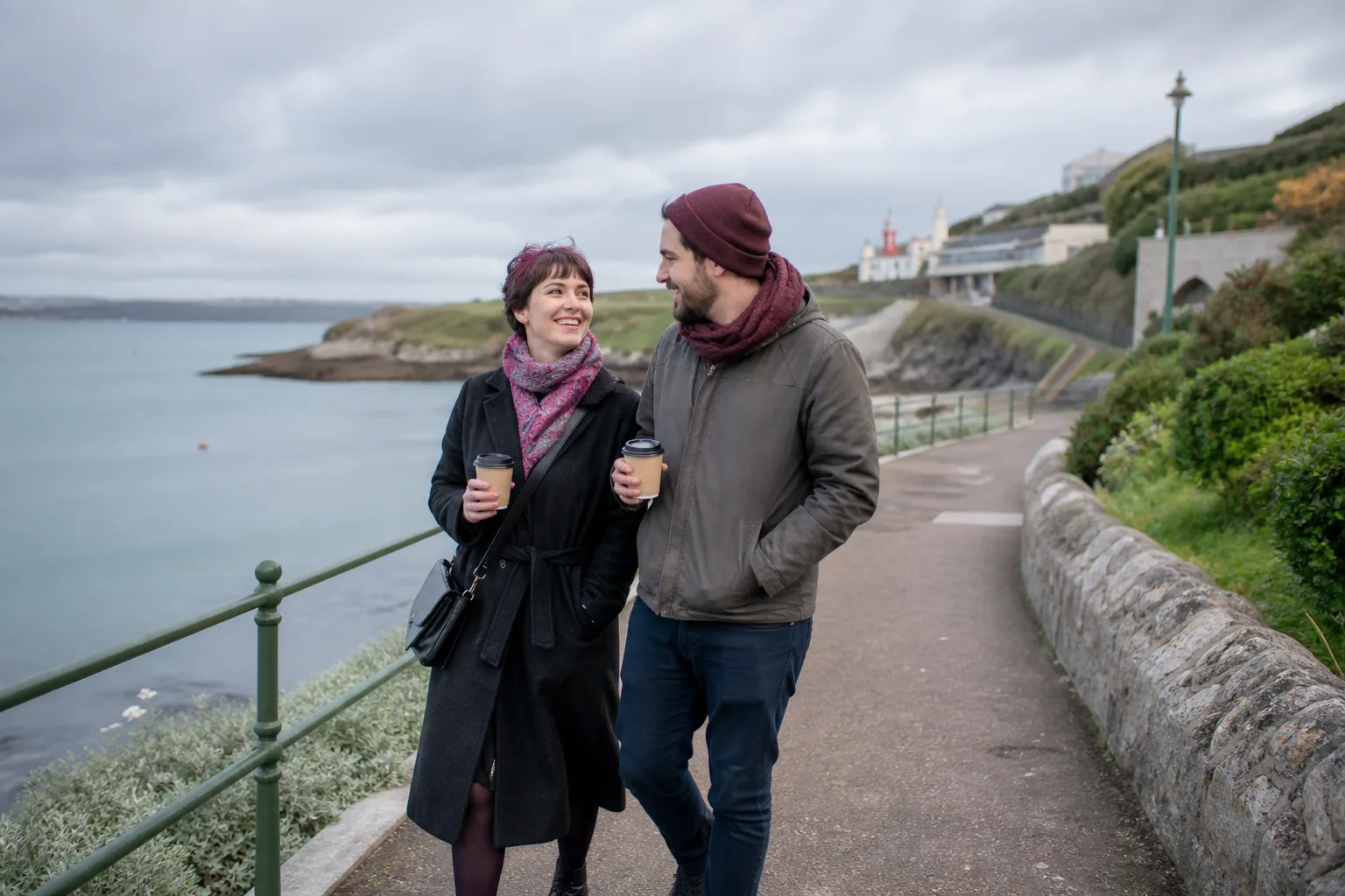 Person creating a dating profile on a phone beside Plymouth waterfront