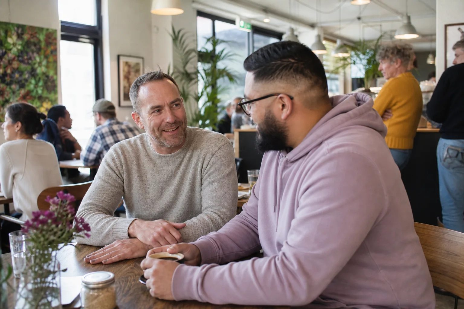 Two men chatting over coffee near Plymouth waterfront